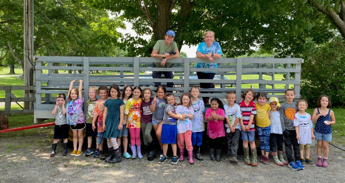 Little Farmers participants pose in front of hay wagon