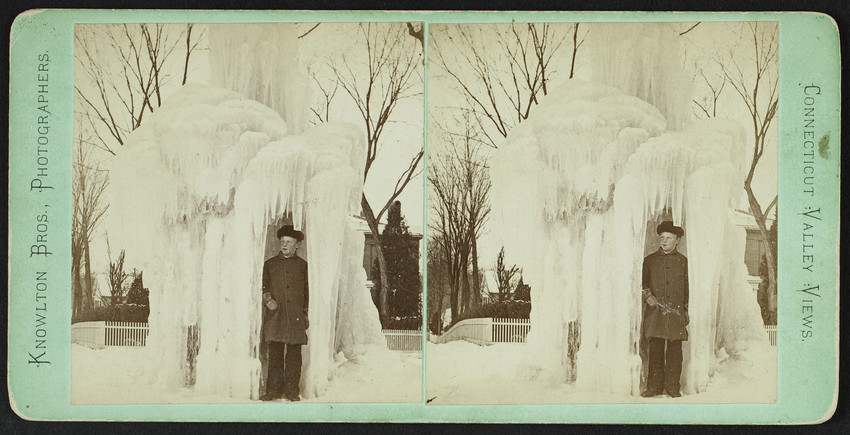 A boy stands under a frozen fountain