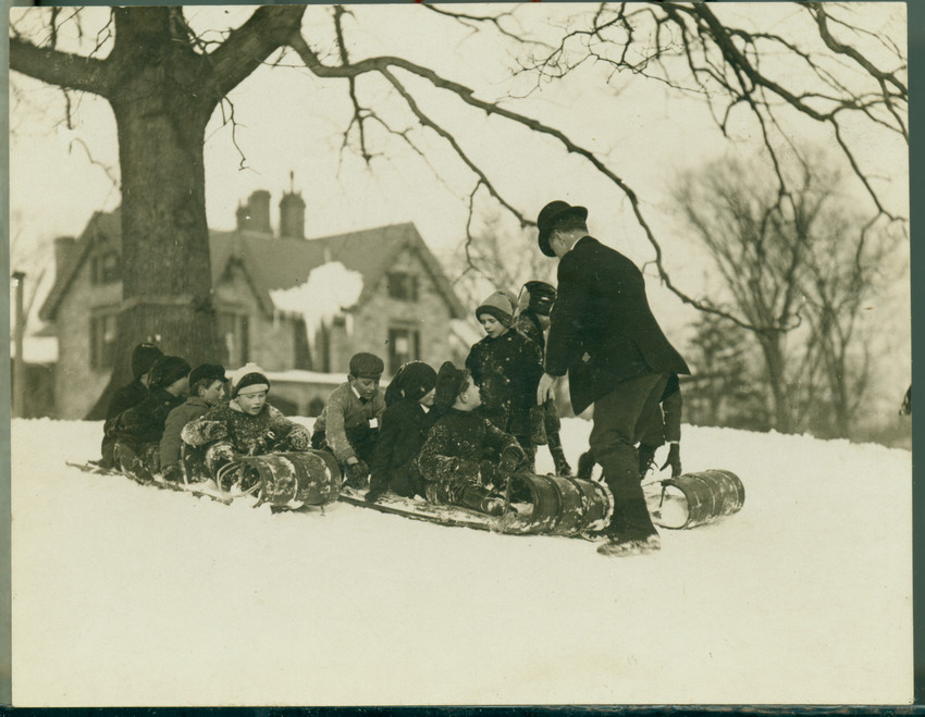 Several children are on a toboggan about to go down a slope